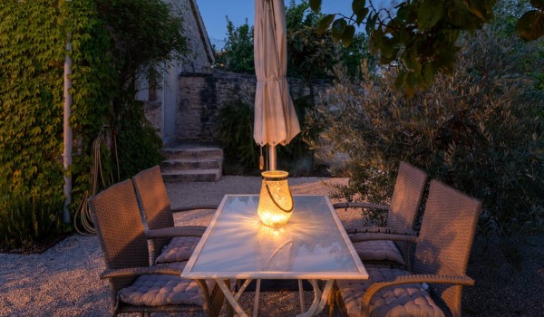 Outdoor dining table with chairs for 4 people in the private landscaped yard of the family holiday villa Deluxe Manor Baderna in Radovani