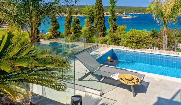 View of the swimming pool of a luxury villa for rent in Šolta by the sea with a sunbed and a sun lounger