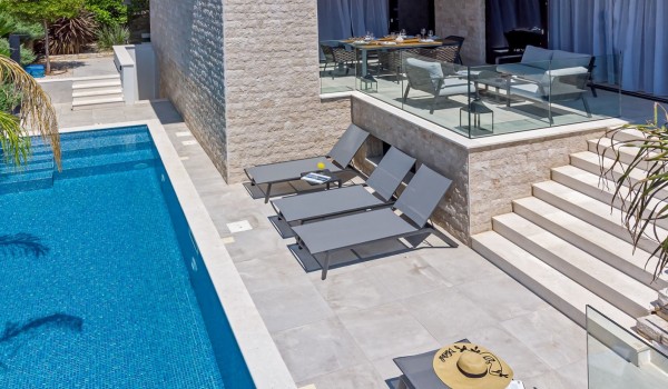 Private sunbathing area next to the swimming pool of the beach front  villa Raquel in Šolta with a lounge area for rest and dining