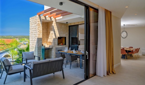 Connected interior and exterior space of a   luxury villa for rent and holiday by the sea on the island of Šolta in Nečujmo with swimming pool and gym