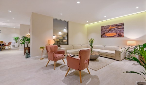 Comfortable corner sofa with armchairs in the air-conditioned living room and a view of the dining room of the  luxury villa for rent Raquel with chef service