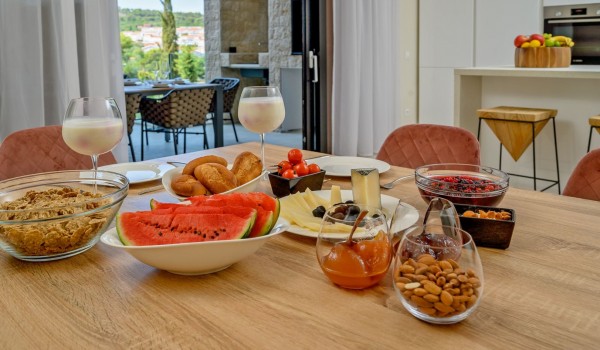 Dining table with food and drinks in a luxury villa for rent by the sea for a  family vacation on the island of Šolta in Nečujam