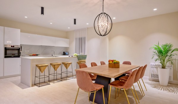 The interior of a modern kitchen, equipped with contemporary appliances with an island and a dining table in a private villa for rent Raquel by the sea on the island of Šolta