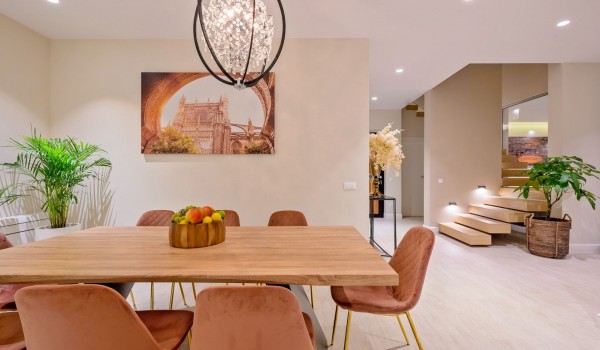 The interior of an elegantly decorated dining room with a view of the illuminated staircase of a pet-friendly luxury villa for rent on Šolta