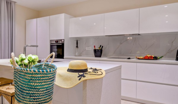 Elegant white kitchen with island and oven and bar stools for socializing with friends in a luxurious villa for rent and vacation with family and friends on the island of Šolta in Nečujmo by 