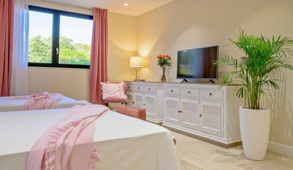 A spacious bedroom with two separate beds, an armchair and SAT TV in a private villa  by the sea for rent on the island of Šolta in Nečujam