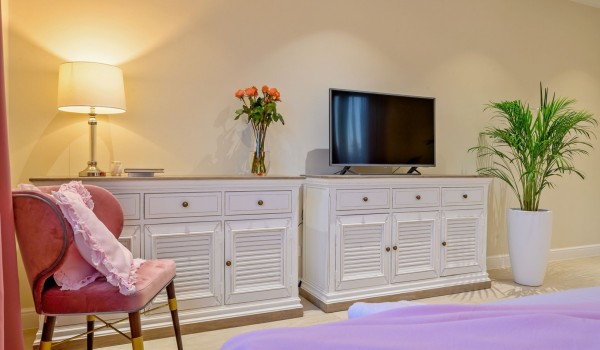 Interior of a modern bedroom with two separate beds, a sitting area and SAT TV of a family villa for vacation and rent on the island of Šolta by the sandy beach