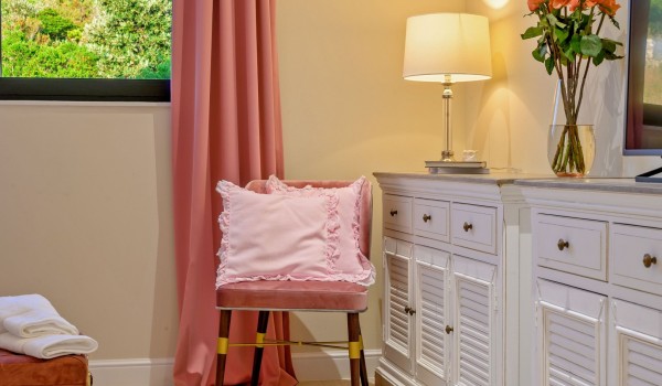 A decorative pillow on an armchair in the airy bedroom of the luxury rental villa Raquel on the island of Šolta, by the sea for 8 persons