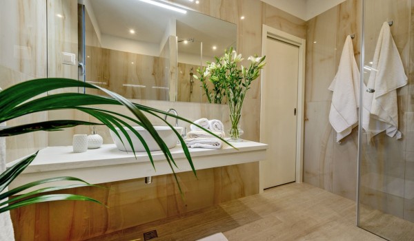 En suite bathroom in neutral tones with walk in shower and sink in luxury  Raquel family holiday villa with pool and gym by the pebble beach in Šolta