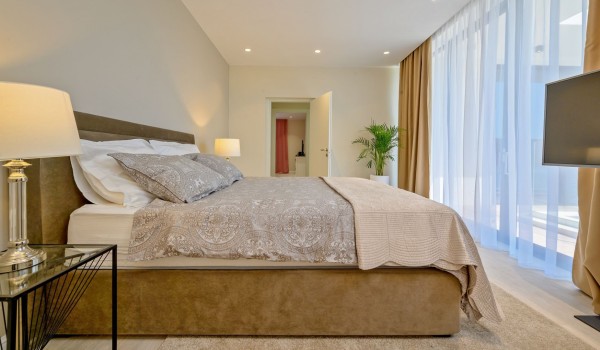 A modernly decorated bedroom with a double bed, LCD TV and Wi-Fi in the Raquel beachfront vacation villa with pool and garden  on the island of Šolta