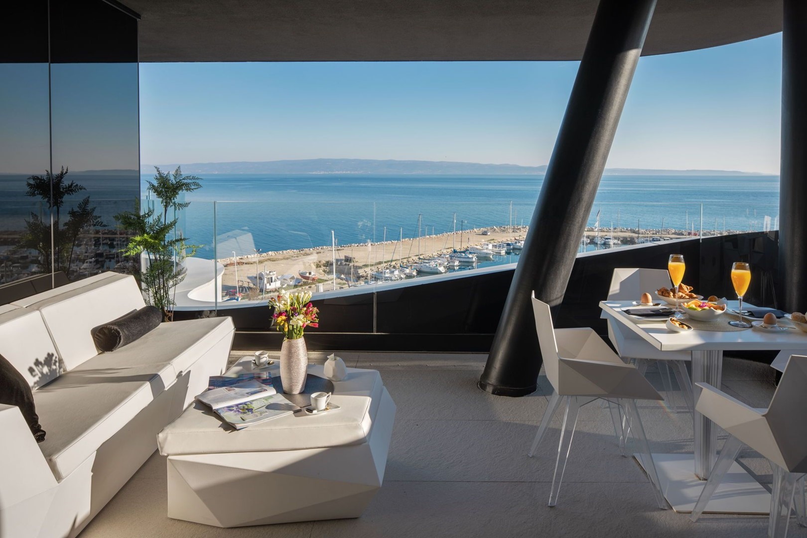 Vanjska terasa luksuznog apartmana Split Gem Luxe sa sjedećom garniturom i stolićem te pogledom na lučicu i more u Splitu