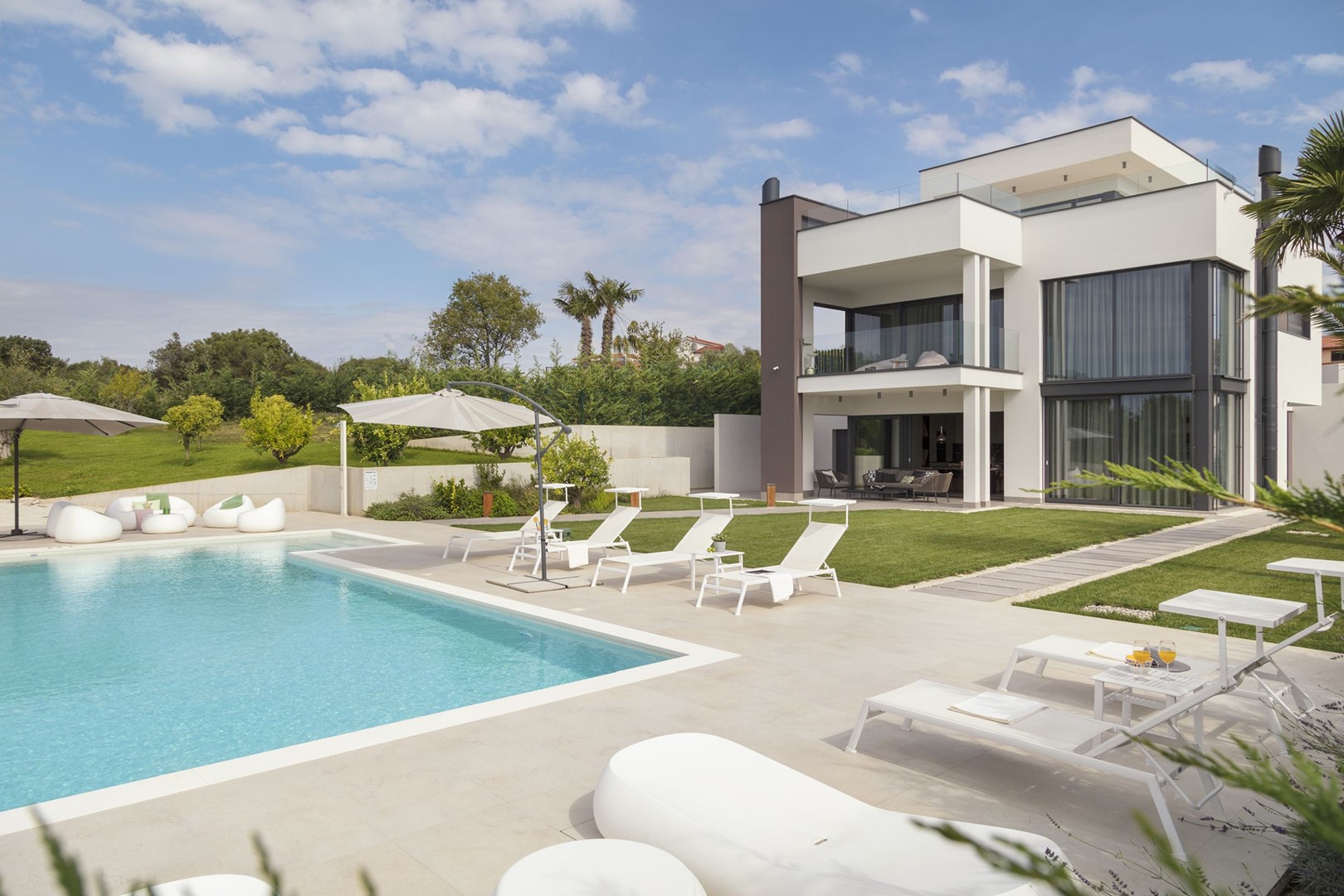 Blick auf die Luxusvilla Deluxe Pula mit privatem Pool und Außenterrasse mit Sonnenliegen und Sonnenschirm
