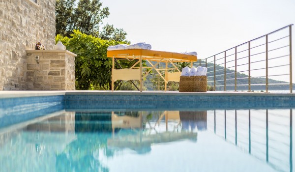 Massage table by the pool of a luxury seafront villa for vacation with friends on Korcula island