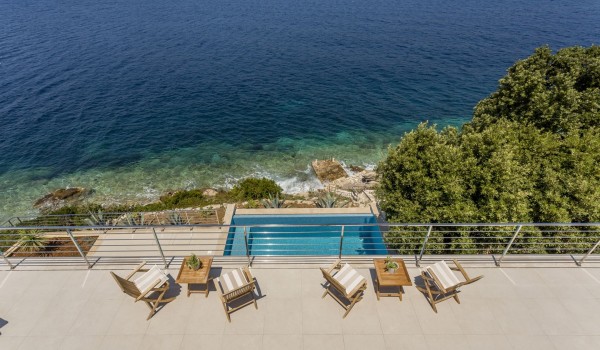 Aerial view of a private infinity pool of a luxury seafront villa for family vacation on Korcula island