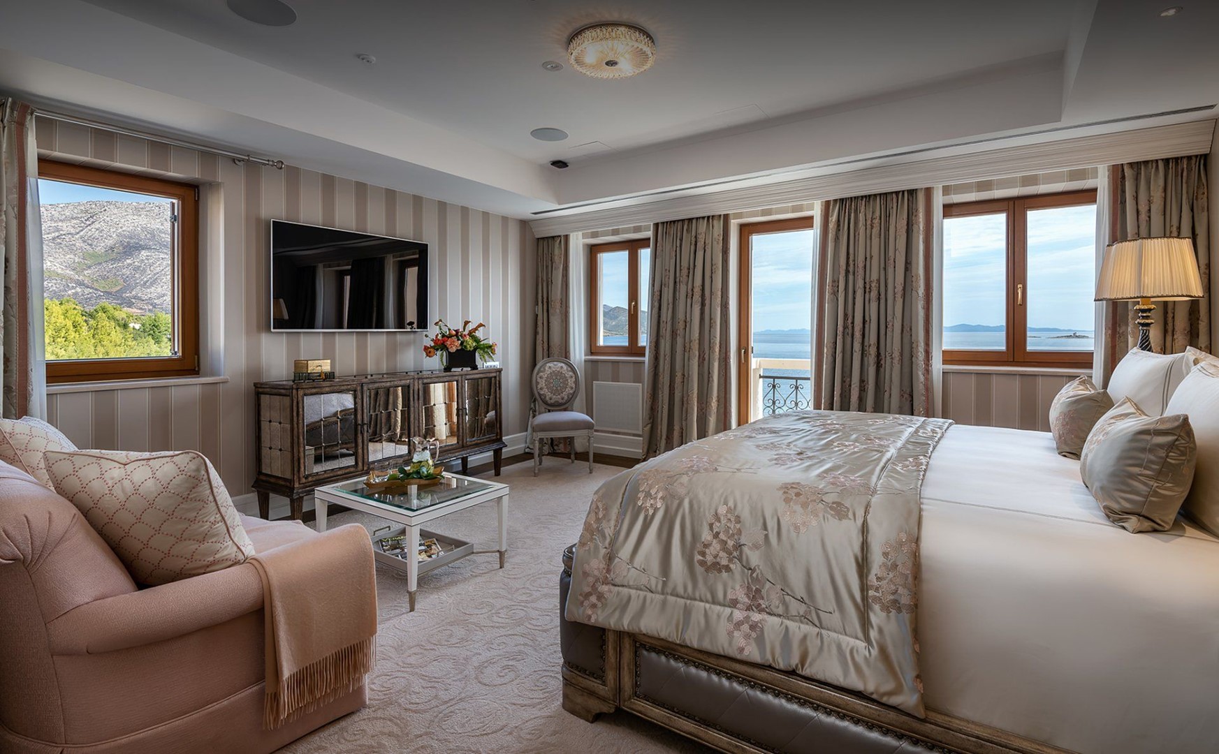 King size krevet i prostor za sjedenje u spavaćoj sobi luksuznog apartmana na plaži sa zajedničkim bazenom i parkingom