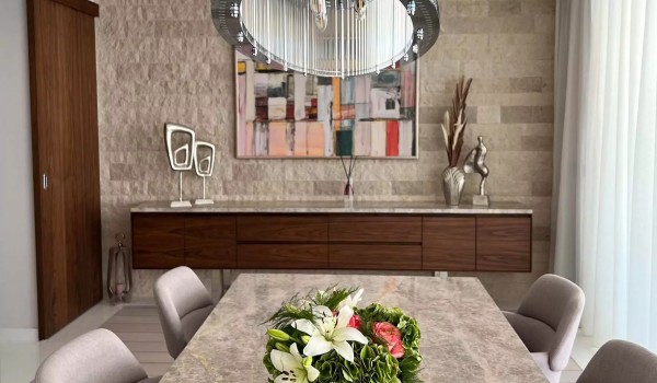 Decoration on the marble dining table on the ground floor of the luxury villa Residenzia Imperiale in Savudrija and a wooden chest of drawers on the stone wall