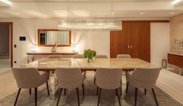 Large modern chandelier above the marble dining table in the contemporary interior of the dining area in the holiday villa Residenzia Imperiale