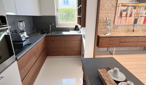 Modern wooden kitchen elements in the fully equipped kitchen next to the dining area on the ground floor of the Residenzia Imperiale family villa with heated pool