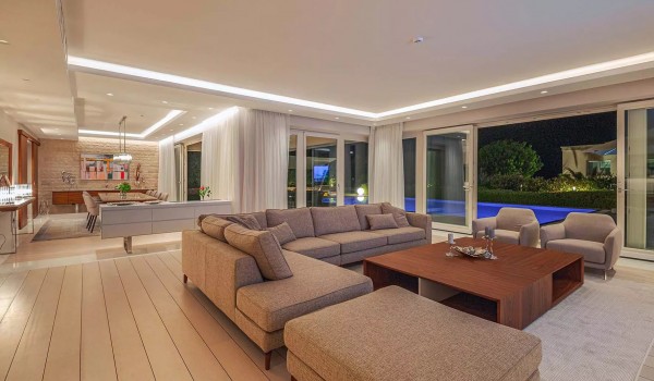 Comfortable corner sofa with a table and two armchairs around a wooden table in the living room on the ground floor of the modern villa Residenzia Imperiale in Istria