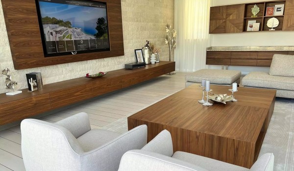 Combination of light colors and wood and stone in the modern interior of the comfortable living room on the ground floor of a family villa with heated pool in Istria
