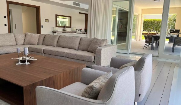 Spacious ground floor of the luxury villa Residenzia Imperiale is divided into a comfortable living room with a corner sofa and two armchairs, and a kitchen with a dining area