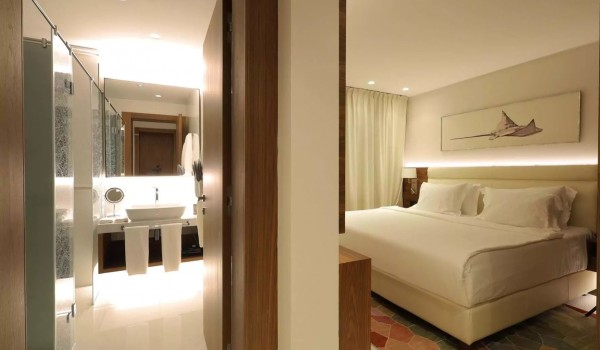 Bedroom with a comfortable king-size bed and an en suite bathroom in a modern newly built villa for vacation and rental Residenzia Imperiale in Savudrija