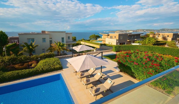 View of the private sunny terrace with pool surrounded by sun loungers from the balcony on the first floor of villa Residenzia Imperiale for rent