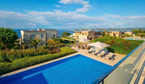 Balcony with a view of the fenced yard with a pool and landscaped garden and sea view