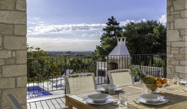 Dining area on roofed terrace in luxury pet-friendly villa in Višnjan for family vacation and rent.