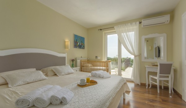 Cozy bedroom with King-size bed in rental luxury villa Višnjan for family vacation and relaxation.