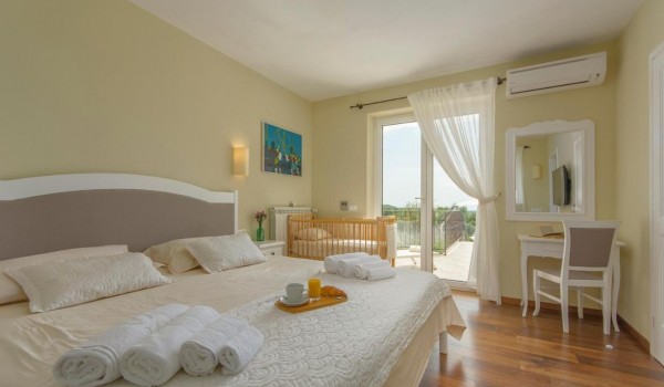 Cozy bedroom with King-size bed in rental luxury villa Višnjan for family vacation and relaxation.