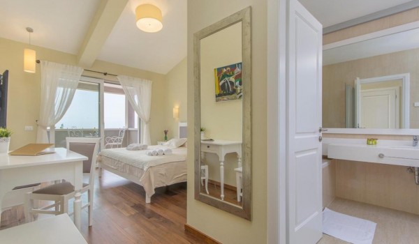 Cozy bedroom with en suite bathroom in rental luxury villa Višnjan for family vacation and relaxation.