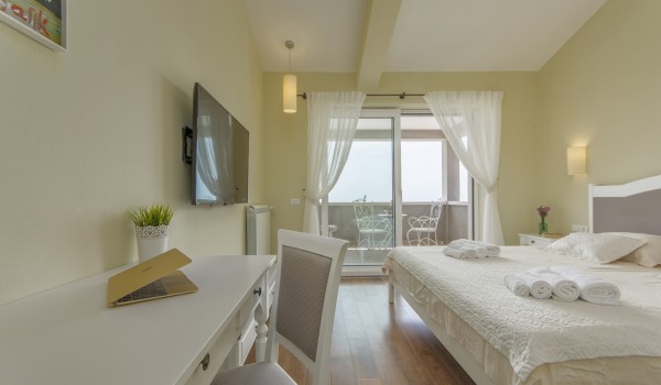 Cozy bedroom with balcony in rental luxury villa Višnjan for family vacation and relaxation.