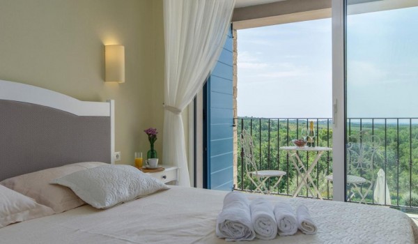 Cozy bedroom with balcony in rental luxury villa Višnjan for family vacation and relaxation.