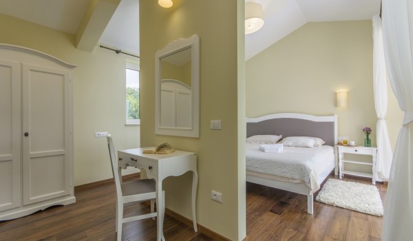 King-size bed in bedroom of luxury pet-friendly villa in Višnjan for vacation and rent.