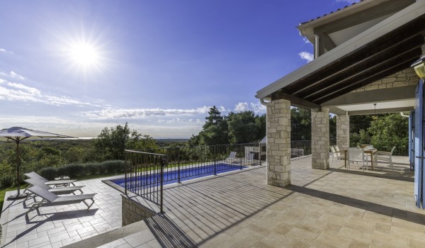 Sunny terrace near pool in pet-friendly luxury villa Višnjan for family vacation and rent.
