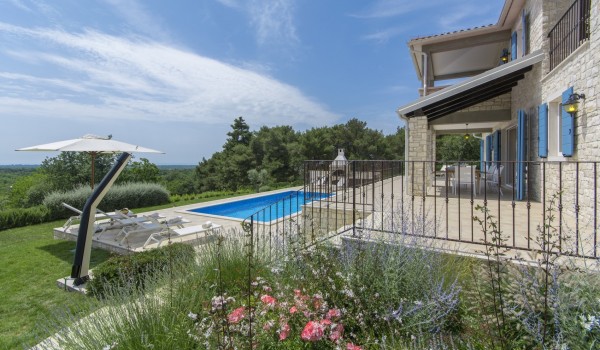 Sunny terrace near pool in pet-friendly luxury villa Višnjan for family vacation and rent.