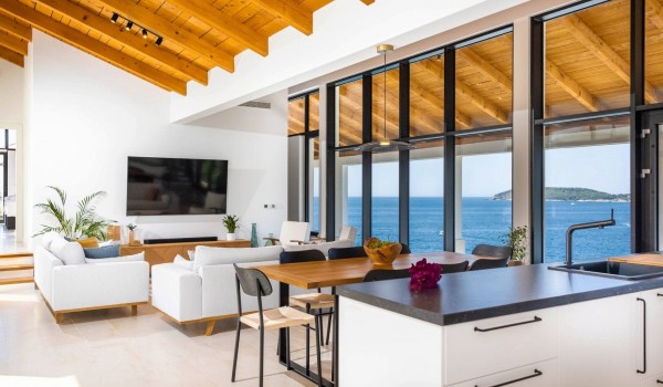Modern dining area in Croatian luxury villa Crystal Palace for family vacation with kitchen island.