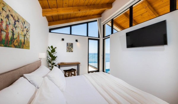 King size bed with bed linen in Croatian luxury villa Crystal Palace in Dubrovnik by the sea for vacation.