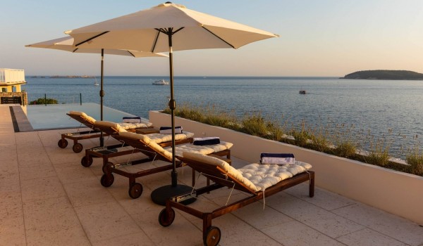 Deck chairs on sunny terrace of dalmatian luxury vacation villa Crystal Palace with private pool and parking.