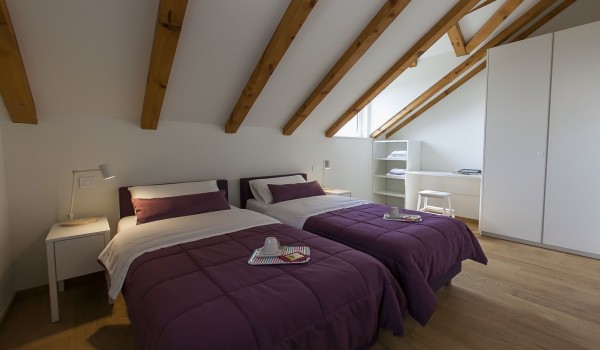 Bedroom with two separate beds and wardrobe in the luxury family villa Aromatica for vacation and rent with family and friends