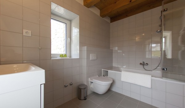 Inside of the bathroom of the luxury family villa Aromatica with the bath tub and sink