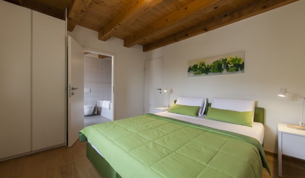 Master bedroom with the king size bed and the private bathroom in the luxurious family villa Aromatica for vacation and rent in Dubrovnik town