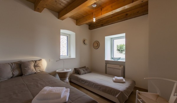 Bedroom of the luxury holiday villa Aromatica with the king size bed and one extra bed for vacation and rent