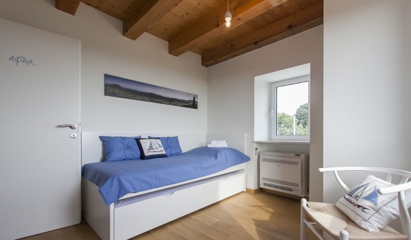 Kids bedroom with the lounge chair in the luxury villa Aromatica in Dubrovnik on Sipan island for vacation and rent