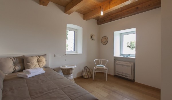 Bedroom with the king size bed and the window overlooking the mountain view in Dubrovnik on Sipan island
