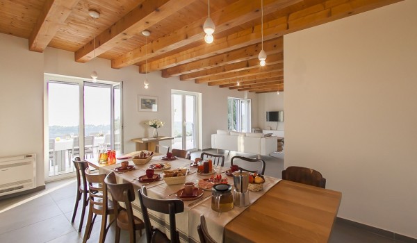Dining room area on the ground floor with the floor-to-ceiling glass windows overlooking the private terrace of the luxury villa Aromatica in Dubrovnik