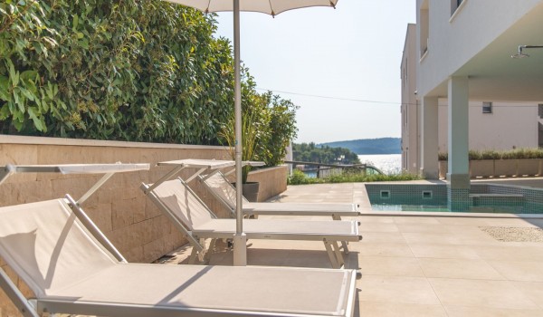 Deck chairs by the pool on the terrace of a Croatia luxury vacation villa with gym and sauna in Trogir