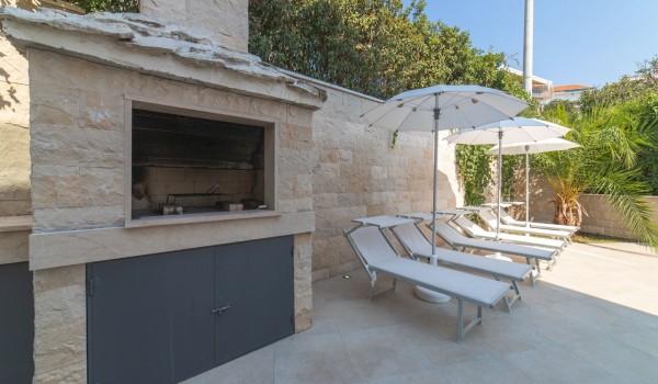 Deck chairs by the pool on the terrace of a Croatia luxury vacation villa with gym and sauna in Trogir