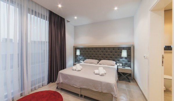 King size bed in a bedroom with en suite bathroom of a Croatia luxury vacation villa with private pool and parking